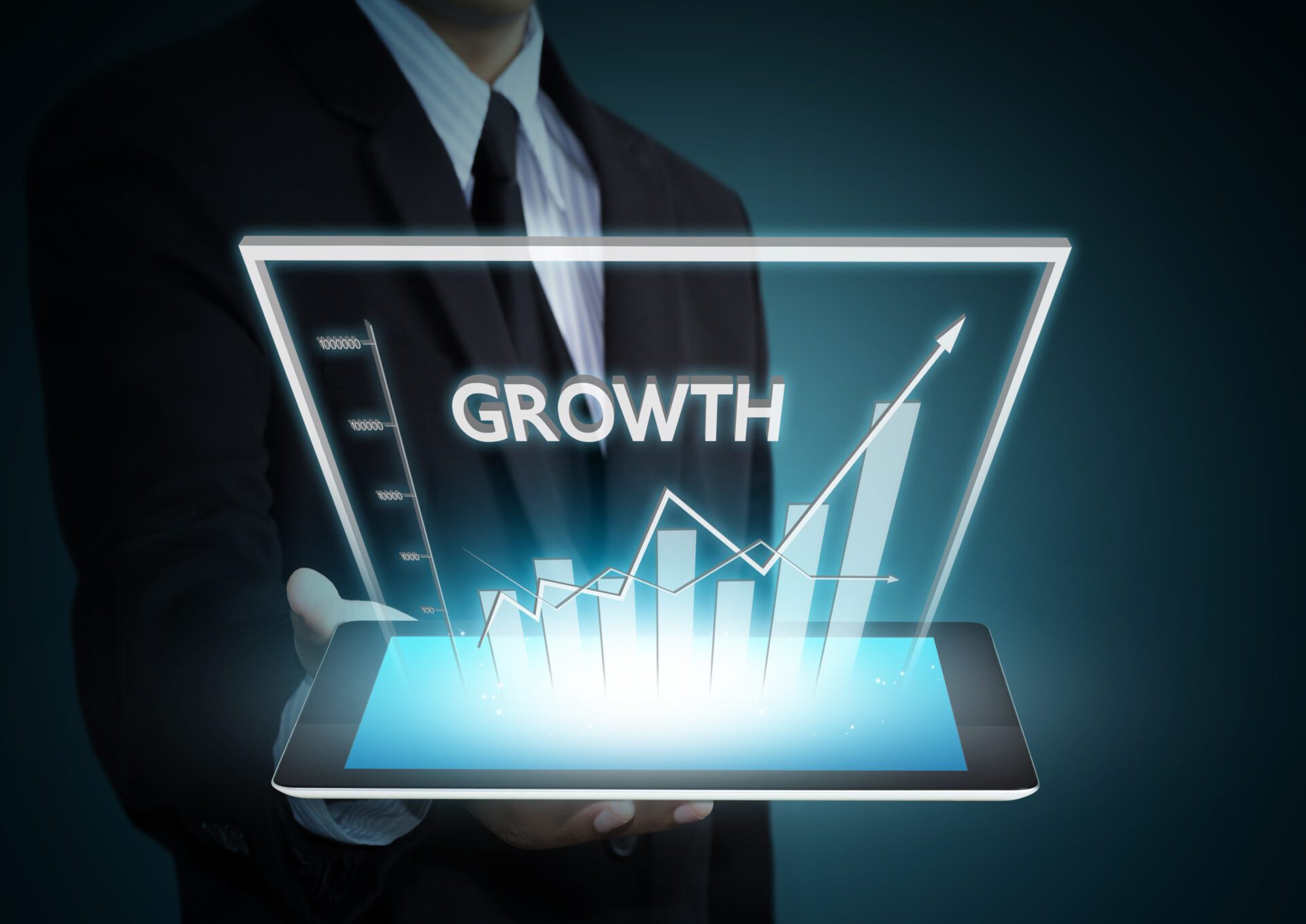 Business hand holding growth graph on tablet technology Business hand holding growth graph on tablet technology